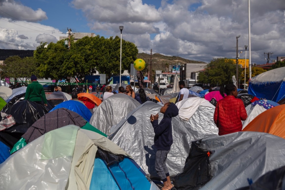 EMX-Negocian desalojo de campamento migrante